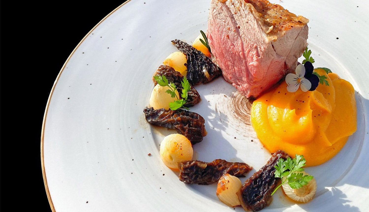 Épaule d’agneau rôtie, purée de courge, oignons grelots et jus aux morilles.