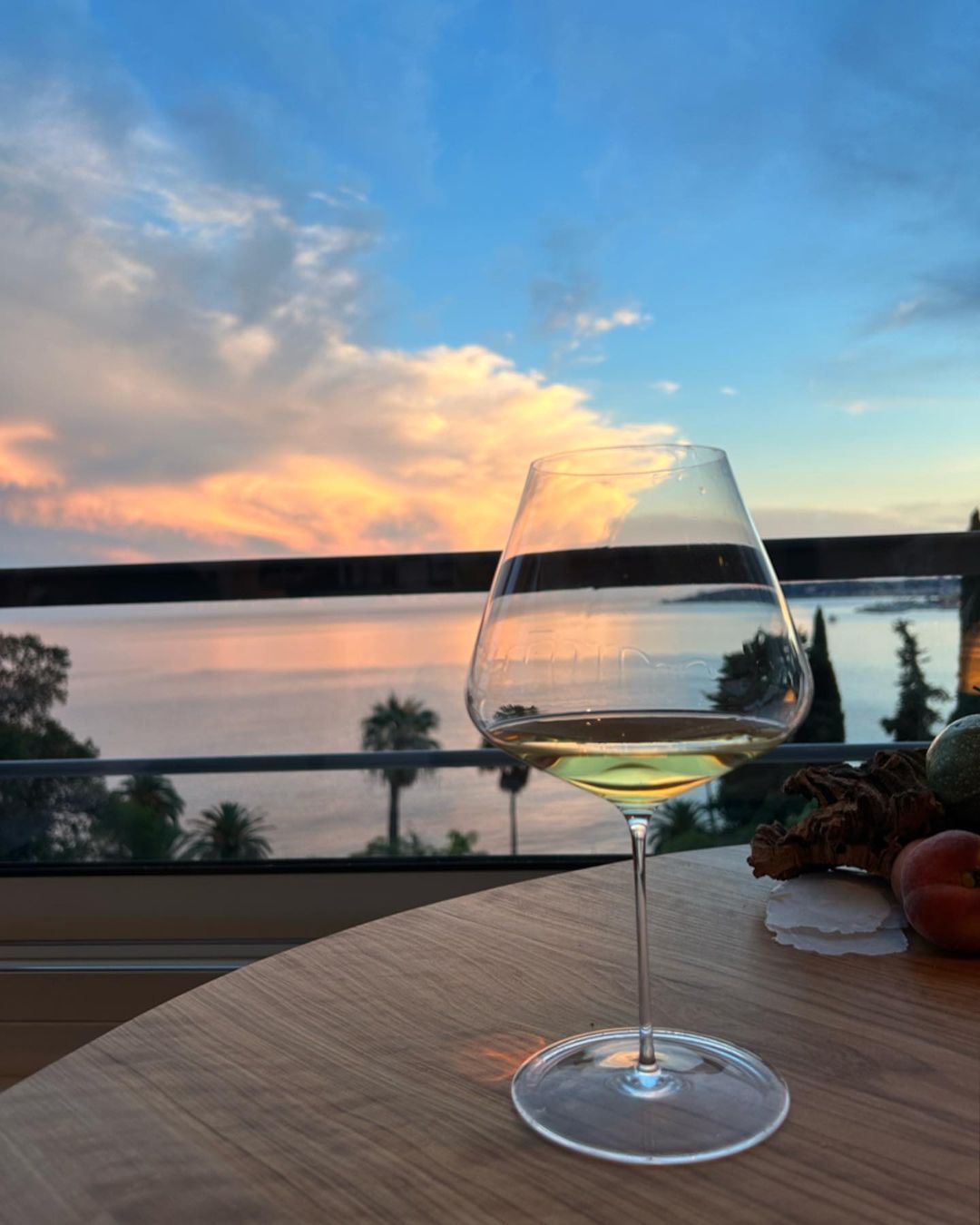 Corton-Charlemagne Grand Cru, un verre sur la terrasse avec couché de soleil sur la mer